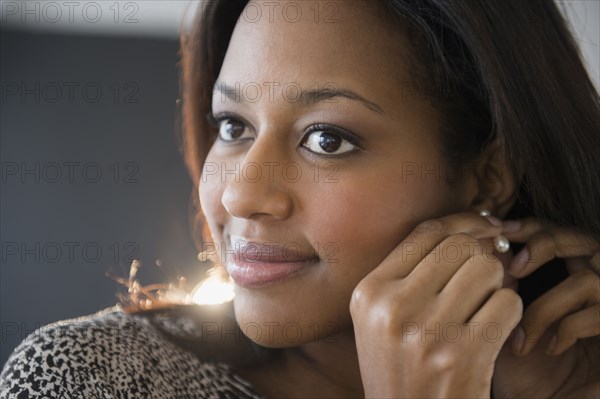 African American woman putting on earrings