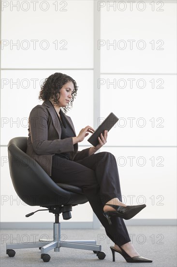 Hispanic businesswoman using digital tablet