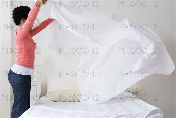 Black woman making bed