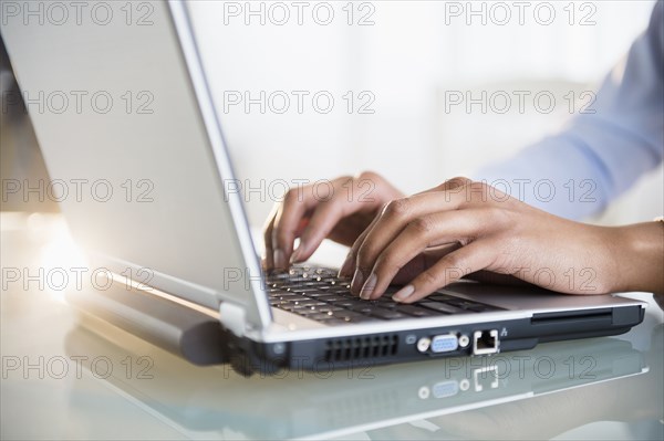 Mixed race businesswoman working on laptop