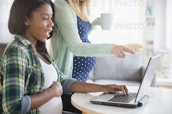 Pregnant women using laptop at table