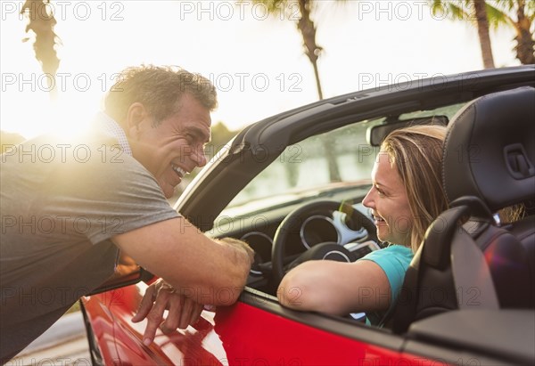 Caucasian couple talking in convertible