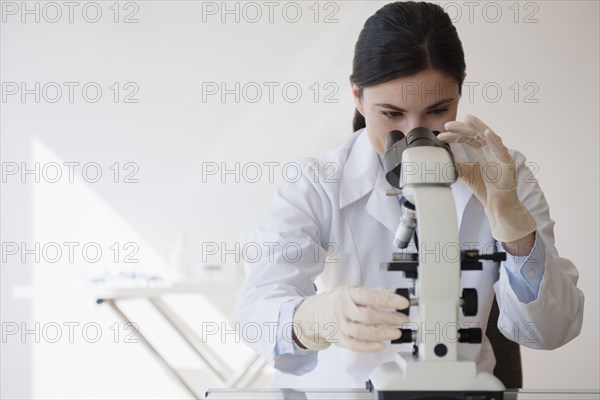 Caucasian scientist using microscope