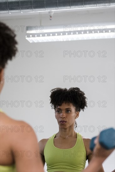 Black woman lifting dumbbells