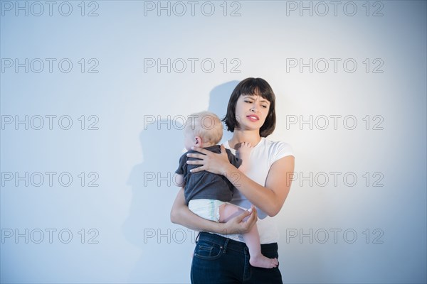 Frustrated mother holding baby son