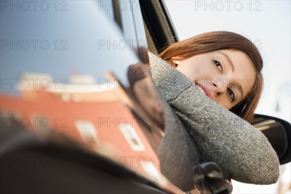 Caucasian woman leaning out car window