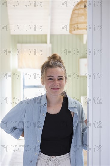 Portrait of teenage girl standing in doorway and smiling