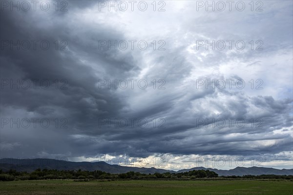 Storm clouds above landscape with meadow