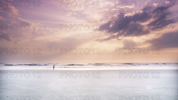 Silhouette of boy on beach at sunrise, Ponte Vedra Beach, Florida, USA