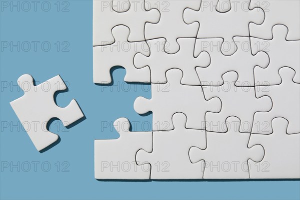 Jigsaw puzzle with missing piece on blue background, New York, NY, USA