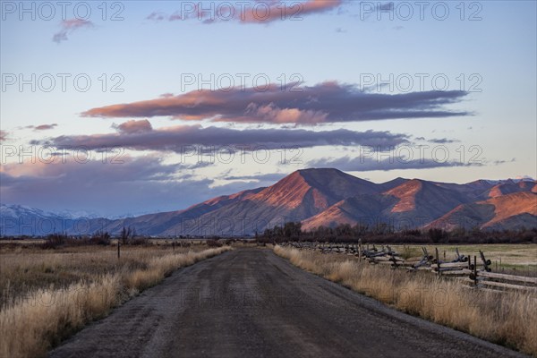 Empty dirt road leading to foothills at sunset, Bellevue, Idaho, USA