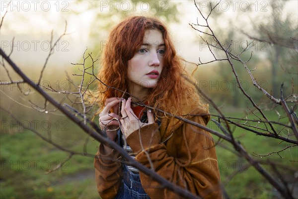 Portrait of redhead women in foggy field in autumn, Omsk, , Russia