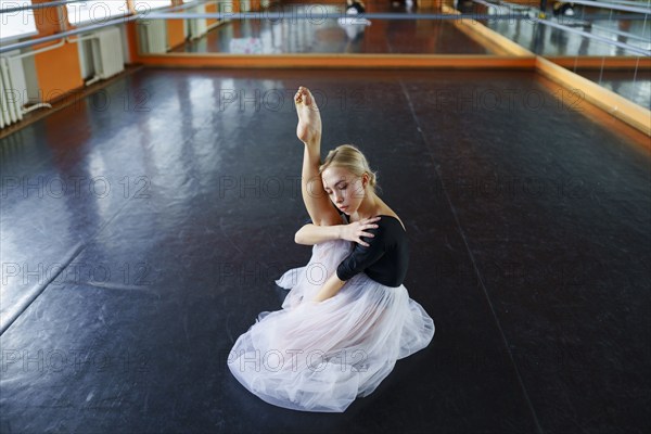 Ballerina sitting on floor in ballet studio, Omsk, , Russia