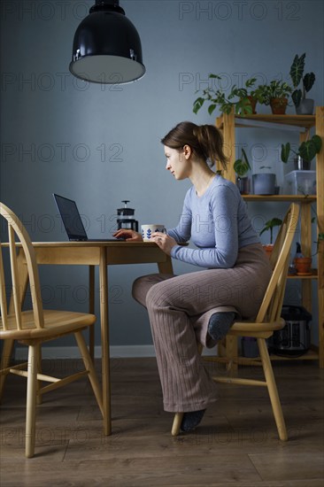 Woman using laptop at home, Omsk, , Russia