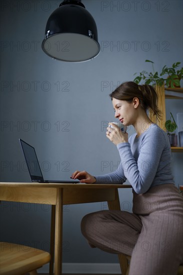 Woman using laptop at home, Omsk, , Russia