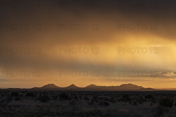 Usa, New Mexico, Santa Fe, Storm and rain over Cerrillos Hills at sunset, Santa Fe, New Mexico, USA