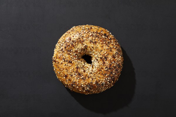 Overhead view of bagel with seeds on black background, New York, New York, USA