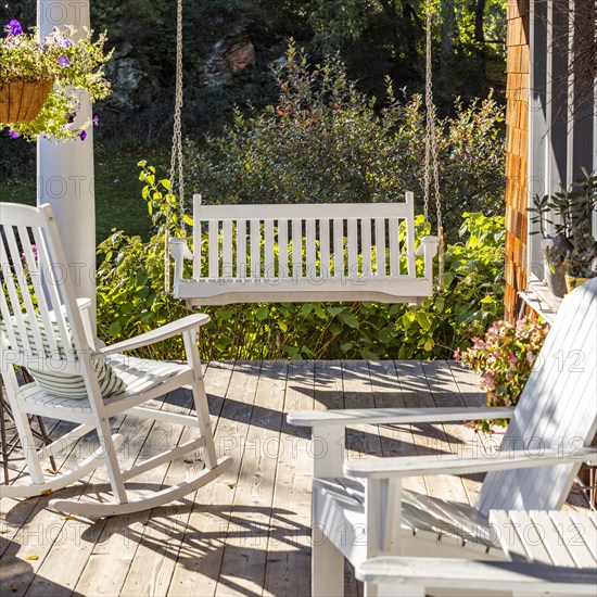 Rocking chair and swing on front porch of cottage house, Mt. Horeb, Wisconsin, USA