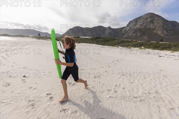 South Africa, Hermanus, Smiling boy running on beach with body board, Hermanus, , South Africa