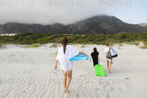 South Africa, Hermanus, Rear view of family walking on beach, Hermanus, , South Africa