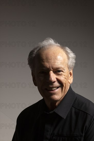 Studio portrait of smiling senior man in black shirt against gray background, Bellevue, Idaho, USA