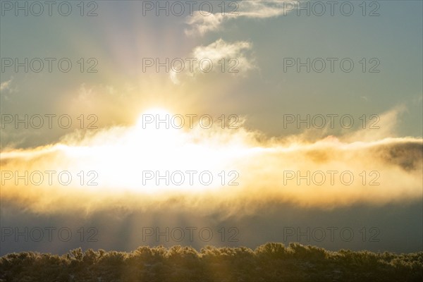 Morning sun bursting through cloudbank, Picabo, Idaho, USA