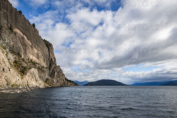 Cumulus clouds over Lake Nahuel Huapi and cliff, Bariloche, Rio Negro, Argentina