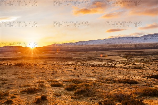 Argentina, Santa Cruz, El Calafate, Sun rising above plain landscape with mountains in distance, El Calafate, Santa Cruz, Argentina