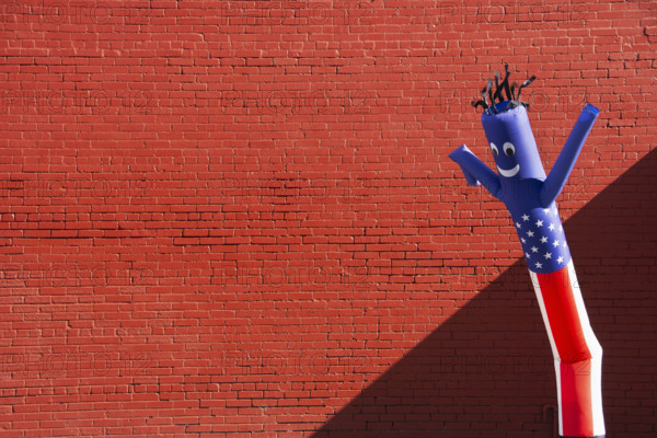 Inflatable tube man with American flag patter against brick wall
Nashville,Tennessee, USA