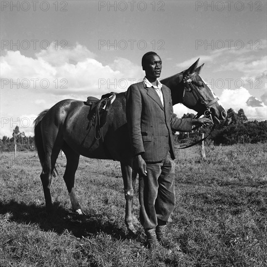 Fosdick's horses. Atmospheric photograph of an African man standing with one of Fosdick's horses at the Kuwinda horse show. Kuwinda, Nairobi, Kenya, 5 December 1954. Nairobi, Nairobi Area, Kenya, Eastern Africa, Africa.