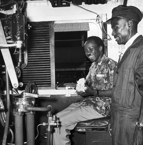 Julius Nyerere in train driver's seat. A publicity photograph from the East African Railways and Harbours Administration (EAR&H) showing Dr Julius Nyerere, the first leader of independent Tanganyika, seated in the driver's seat of a train, the engine driver standing beside him. Tanganyika (Tanzania), circa 1961. Tanzania, Eastern Africa, Africa.