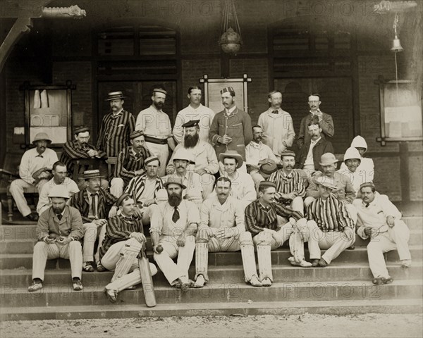 Mofussil and Bombay city cricket teams. Group portrait of the Mofussil and Bombay city cricket teams dressed in their whites outside a colonial-style residency building. Bombay (Mumbai), India, circa 1875. Mumbai, Maharashtra, India, Southern Asia, Asia.