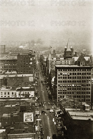 City street in Toronto. View of a busy city street lined with vehicles and crowds of pedestrians. Toronto, Canada, 5-15 August 1924. Toronto, Ontario, Canada, North America, North America .