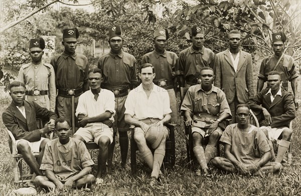 Akim Oda Forest Reserve staff. Group portrait of African staff at the Akim Oda Forest Reserve, with European forestry employee R.M. Hanley, and uniformed soldiers of the King's African Rifles. Gold Coast (Ghana), 1939. Akim Oda, East (Ghana), Ghana, Western Africa, Africa.