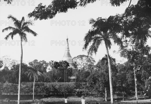 The Shwe Dagon Pagoda. The golden dome of the Shwe Dagon Pagoda rises up behind a formal garden in Rangoon. Rangoon (Yangon), Burma (Myanmar), circa 1925. Yangon, Yangon, Burma (Myanmar), South East Asia, Asia.