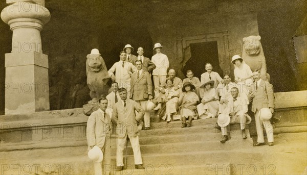 Entrance to the Elephanta Caves. A group of European visitors pose for the camera on steps outside the entrance to the Elephanta Caves. Elephanta Island, Maharashtra, India, circa 1920. Elephanta Island, Maharashtra, India, Southern Asia, Asia.