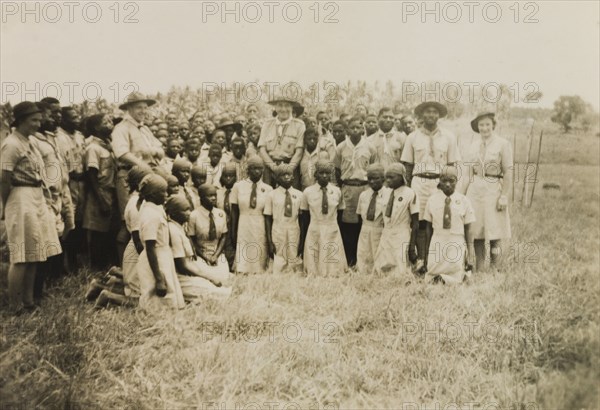 Kenyan scouts and guides. A group of uniformed Kenyan scouts and guides pose for the camera outdoors at an inspection of scouts and guides by Sir Charles Mortimer, the Commissioner for Lands. Coast Province, Kenya, circa 1950., Coast, Kenya, Eastern Africa, Africa.