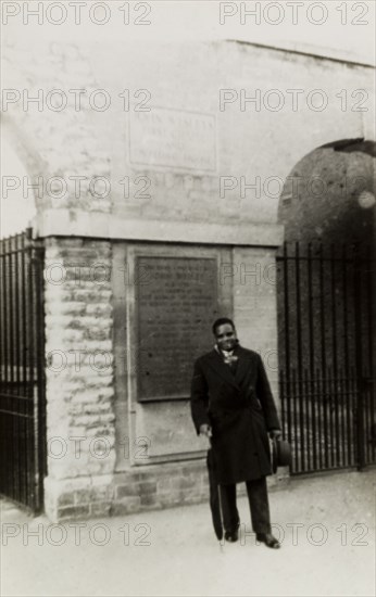 Reverend Ronald Mgongo at Bristol. Portrait of Reverend Ronald Mgongo, the first Bishop to be appointed to the new multiracial Methodist church of Mombasa, Kenya. He is pictured beneath a plaque that reads: 'John's Wesley's First Chapel and Dwelling House'. Bristol, England, circa 1956. Bristol, Bristol, England (United Kingdom), Western Europe, Europe .