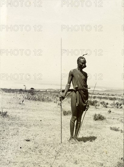 Maasai warrior. Full-length portrait of a Maasai warrior, spear in hand. British East Africa (Kenya), 1906. Kenya, Eastern Africa, Africa.