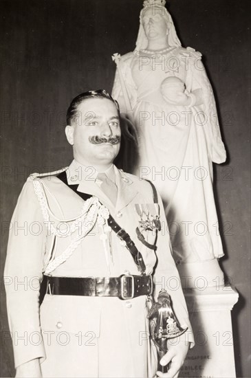 Portrait of A.T. Bevan. Portrait of A.T. Bevan, aide-de-camp to the Governor of Singapore, Sir Franklin Gimson, in front of a statue of Queen Victoria at Government House. Singapore, Singapore, circa 1950. Singapore, Central (Singapore), Singapore, South East Asia, Asia.