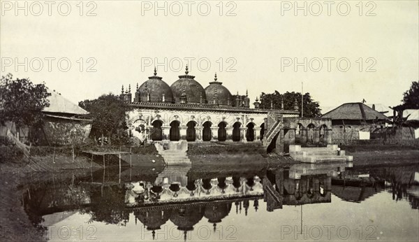 Waterside temple, India. Steps lead down into a pool of water from a temple decorated with arches and domes. India, circa 1890. India, Southern Asia, Asia.