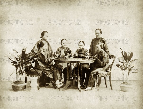 Chinese ladies playing 'fantan'. Studio portrait of six Chinese ladies playing a card game identified in the original caption as 'fan-tan'. Probably Hong Kong, (People's Republic of China), circa 1895. China, People's Republic of, Eastern Asia, Asia.