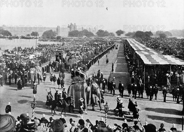 State entry procession at the Coronation Durbar. Crowds line the streets to watch the state entry procession of the Coronation Durbar as it approaches the Jama Masjid. British dignitaries and Indian Maharajahs ride in howdahs on the backs of bejewelled elephants, amongst them Lord and Lady Curzon and the Duke and Duchess of Connaught. Delhi, India, 29 December 1902. Delhi, Delhi, India, Southern Asia, Asia.