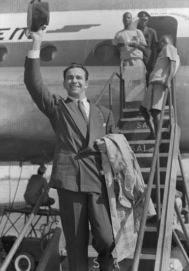 John Bentley arrives in Nairobi. Hollywood film star John Bentley waves his trilby hat as he disembarks from a plane at Eastleigh airport. Nairobi, Kenya, 9 November 1952. Nairobi, Nairobi Area, Kenya, Eastern Africa, Africa.