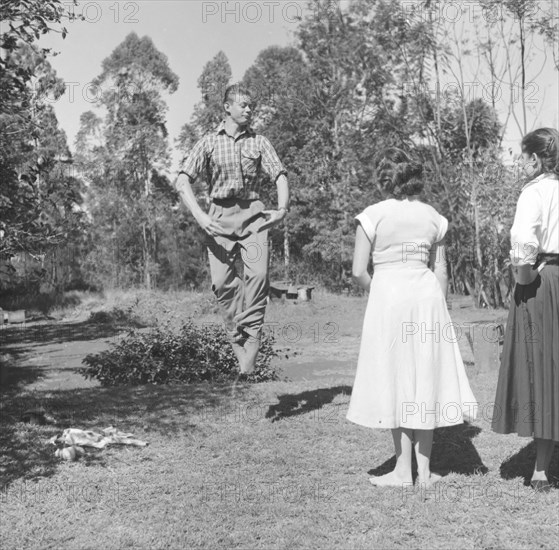 Ballet jump practice. A male dancer demonstrates a ballet jump during an outdoors rehearsal for a square dance cabaret. Kenya, 7 December 1952. Kenya, Eastern Africa, Africa.