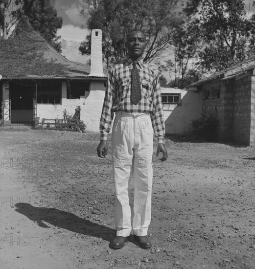 Portrait of 'Robert'. A Kenyan man identified as 'Robert', poses stiffly for the camera dressed in smart clothes. An original caption identifies him as a principal domestic servant of Charles Trotter, the photographer of this image. Kenya, 1 January 1953. Kenya, Eastern Africa, Africa.