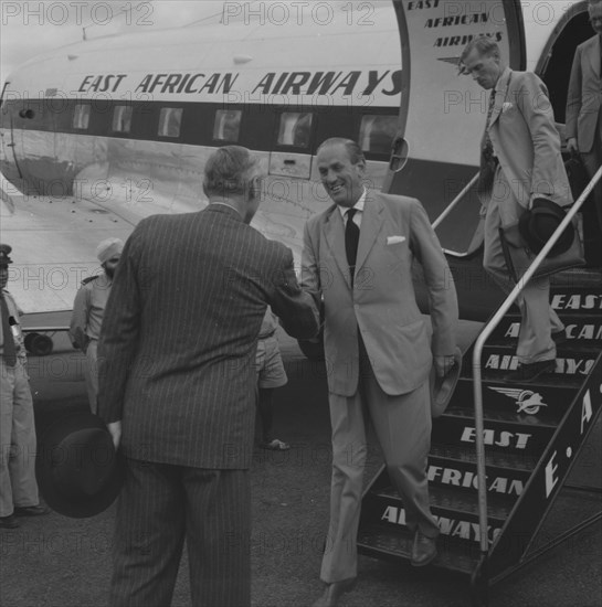Governor greets Lennox-Boyd. Alan Tindal Lennox-Boyd (1904-1983) disembarks from an East African Airways plane to be greeted by Sir Evelyn Baring, Governor of Kenya. Kenya, 11 October 1957. Kenya, Eastern Africa, Africa.