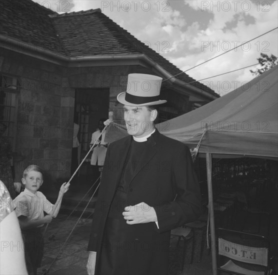 Padre in a top hat. Portrait of the padre who presided at the Coltart wedding ceremony. He is pictured sporting a top hat belonging to either the groom or best man. Kenya, 9 November 1957. Kenya, Eastern Africa, Africa.