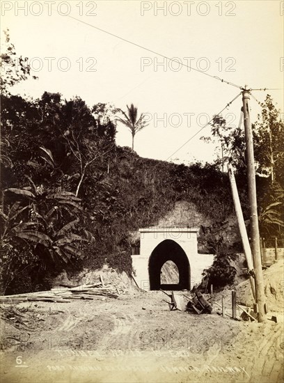 Railway tunnel 'No. 15'. Discarded wheelbarrows and timber litter the entrance to railway tunnel 'No. 15'. The tunnel is shown before the construction of the railway track that would later run beneath it as part of the Port Antonio extension line. Portland, Jamaica, circa 1895., Portland, Jamaica, Caribbean, North America .