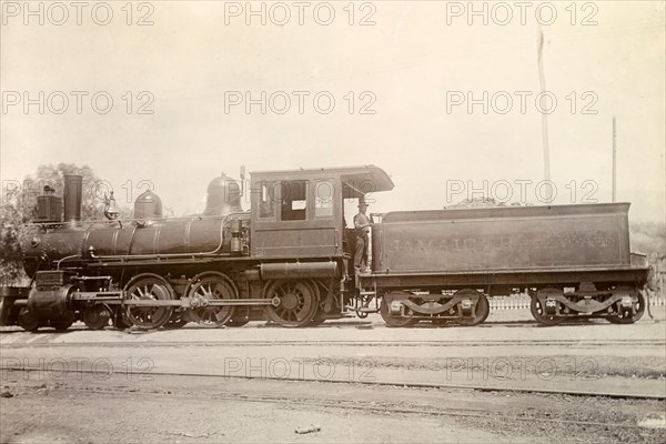 American steam locomotive, Jamaica. An American-manufactured steam locomotive sits on rails at a siding. Jamaica, circa 1895. Jamaica, Caribbean, North America .